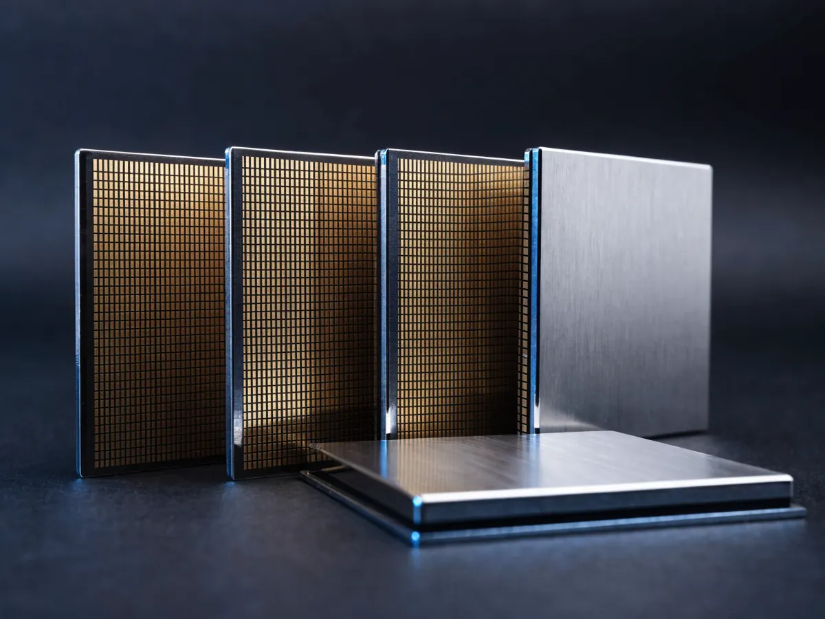 Three medium sized processors standing on edge showing their gold contact pads, with a fourth lying flat in front showing a blank metal lid