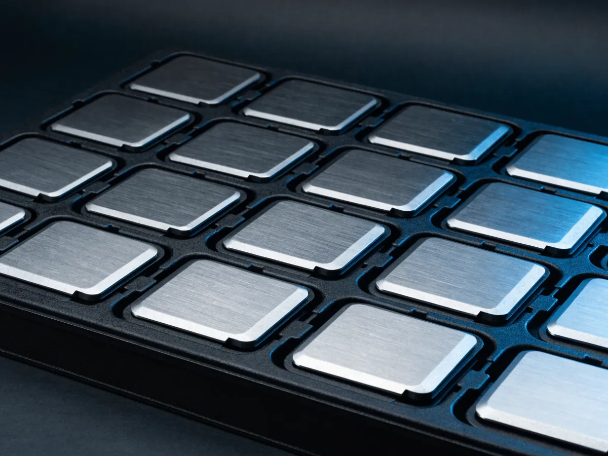 Overhead view of a plain black anti static tray holding a grid of twenty identical server processors in individual pockets