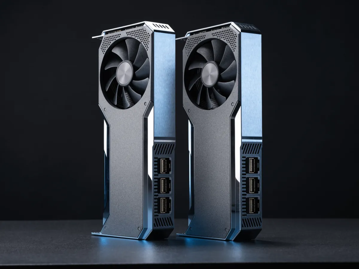Two dual slot workstation graphics cards standing on edge side by side, each with a circular blower fan opening and a vented bracket carrying four DisplayPort sockets