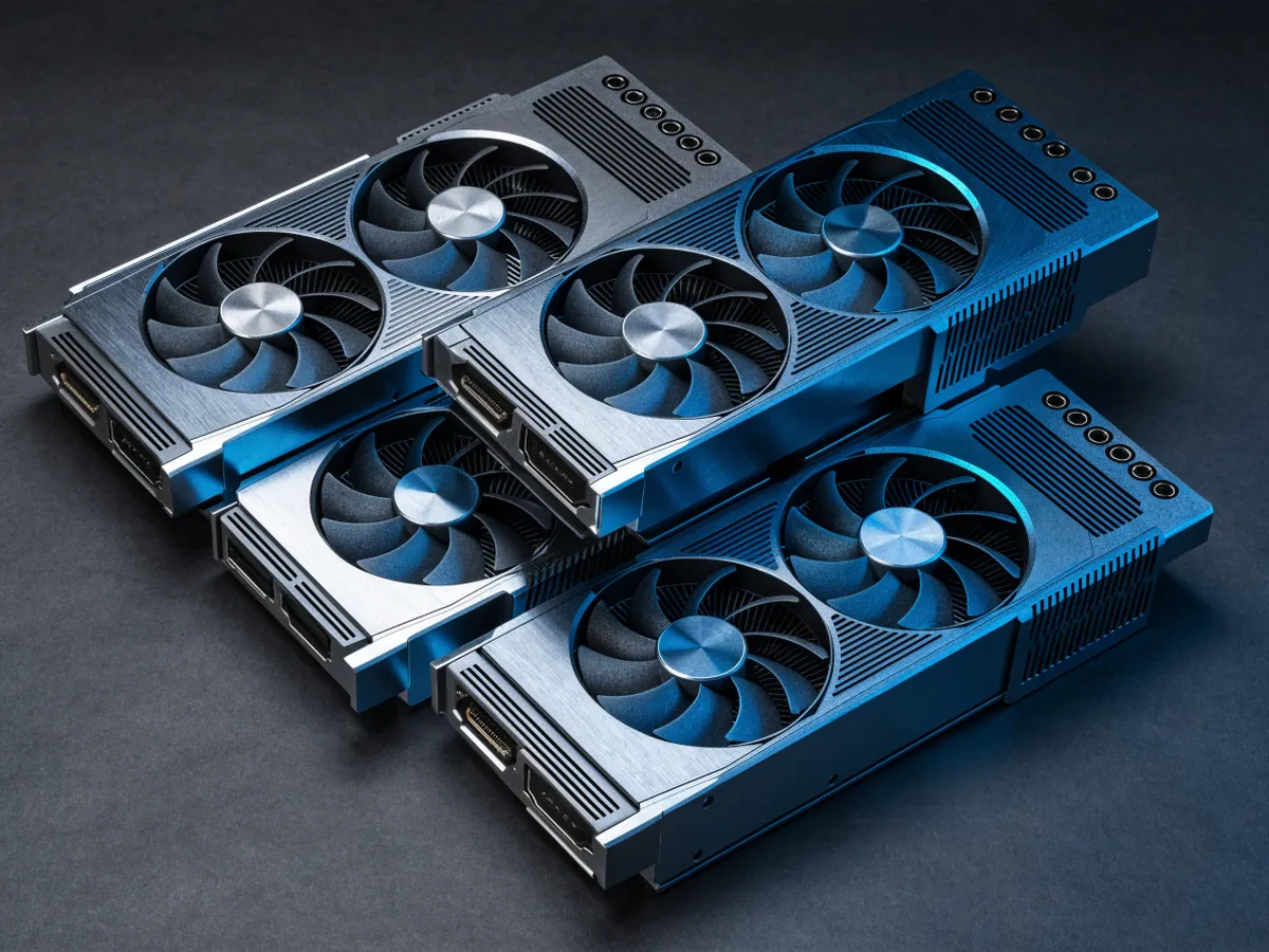 Five consumer desktop graphics cards stacked flat in a loose pile, open air coolers with two and three axial fans, metal backplates and top edge power sockets