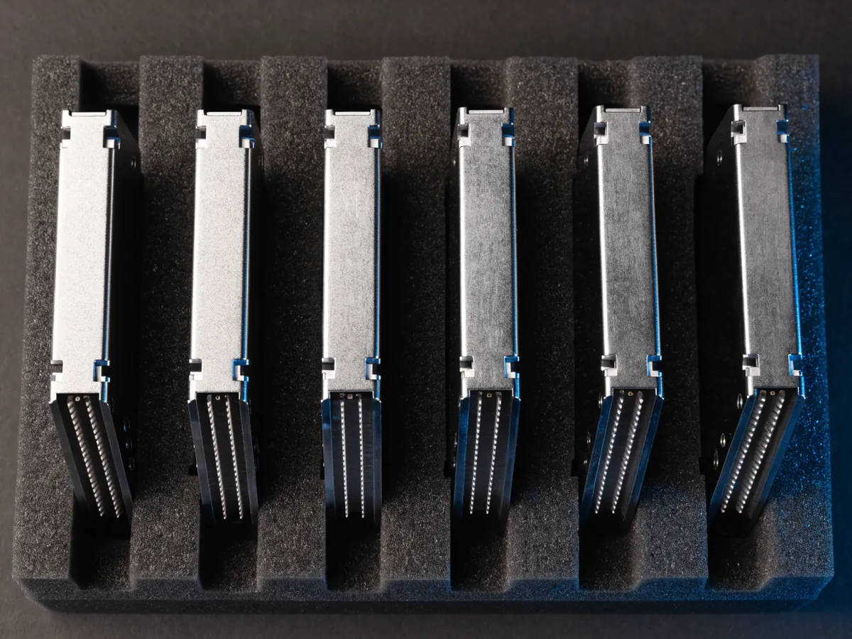 Six 3.5 inch hard disk drives standing on edge in a black foam tray, photographed from above at an angle