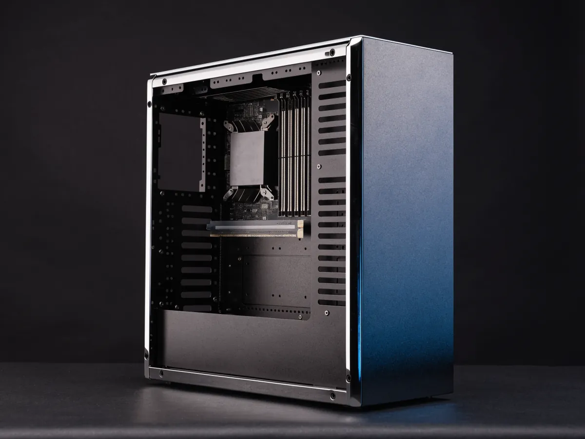 A full height tower computer chassis with the side panel removed, showing a large heatsink, memory slots, one expansion card and a power supply cage