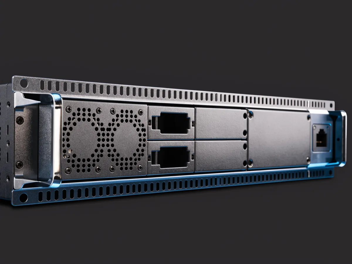 Rear of a 1U rackmount switch on a dark background, showing two removable fan modules, two hot swap power supply modules and one blanked bay