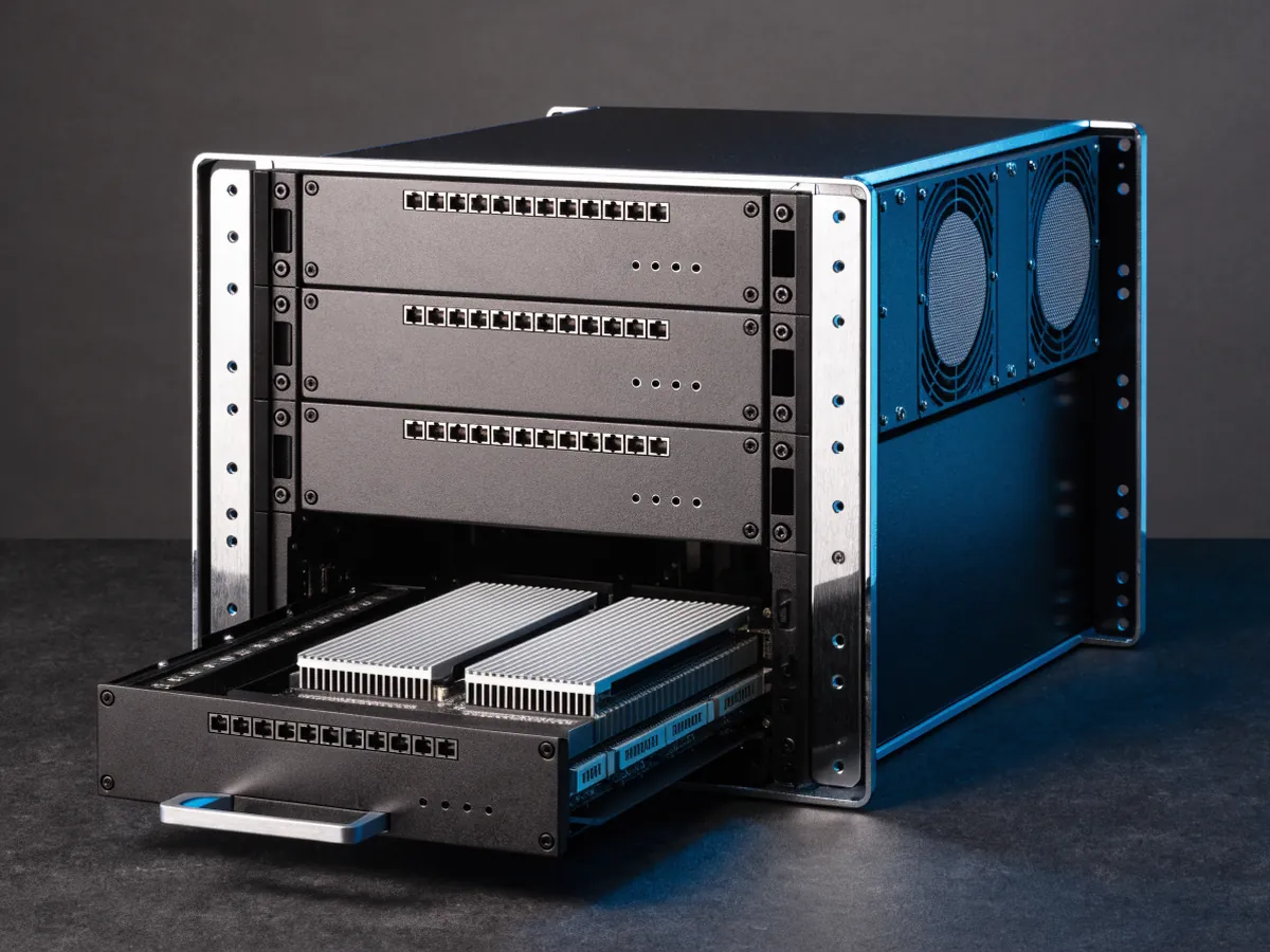 Rear of a 2U chassis divided into four node bays with one compute sled pulled halfway out, showing its motherboard, heatsinks and memory modules, on a dark background