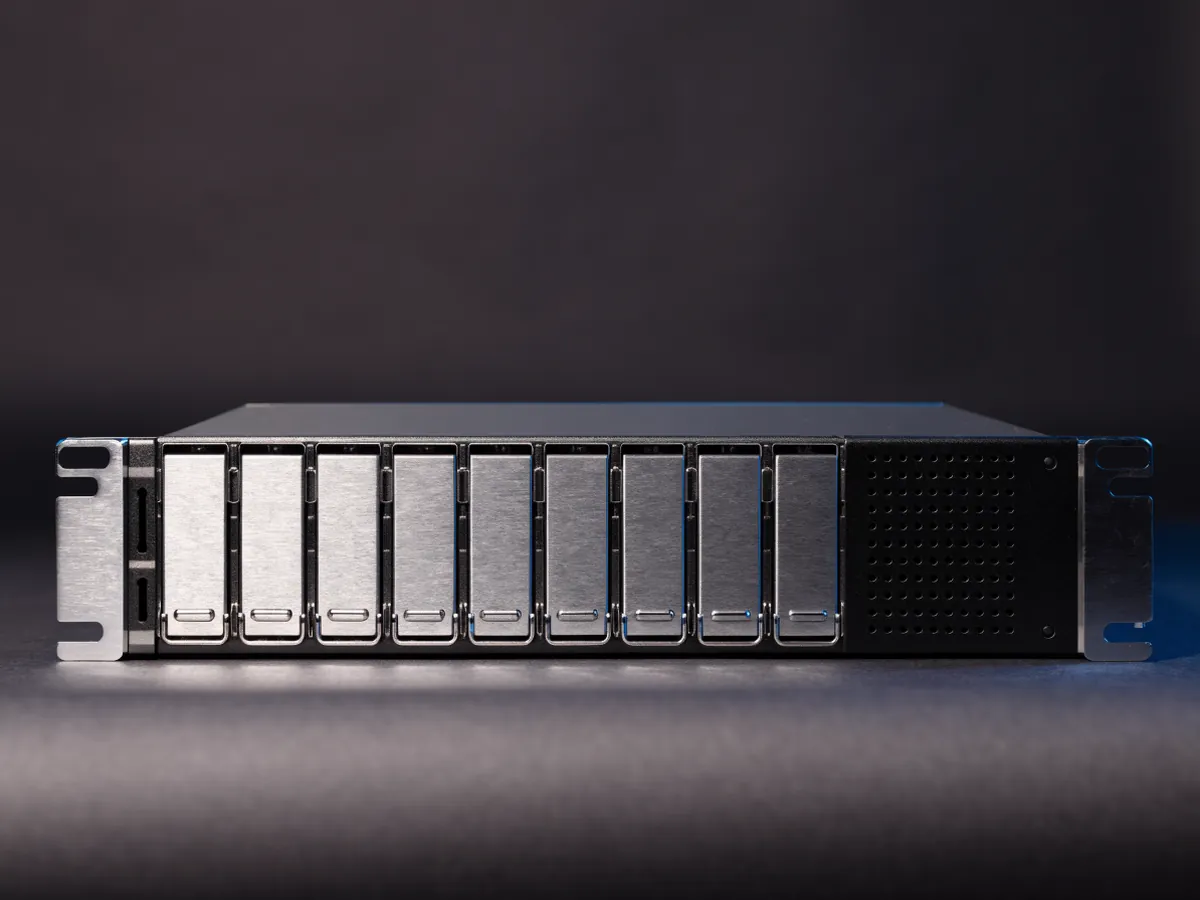 Front view of a 1U rackmount server chassis with a row of eight blank 2.5 inch drive carriers, photographed under cool studio lighting on a dark background