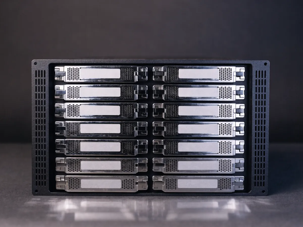 Front view of a 2U rackmount server chassis filled with twelve blank 3.5 inch drive carriers in a four by three grid, lit evenly on a dark background