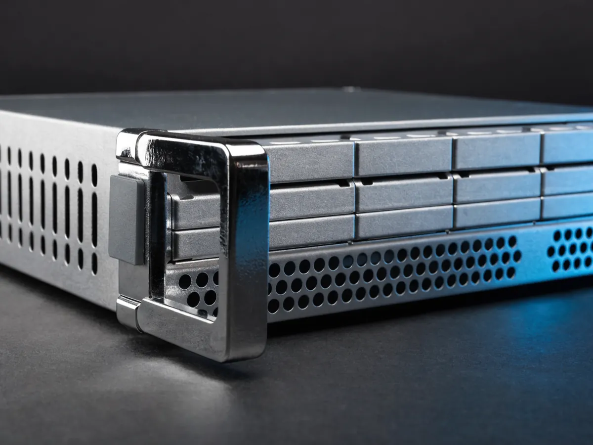 Angled close view of the rack mounting ear, latch handle and blank pull out identification tab on the front of a 1U server chassis, under cool studio lighting
