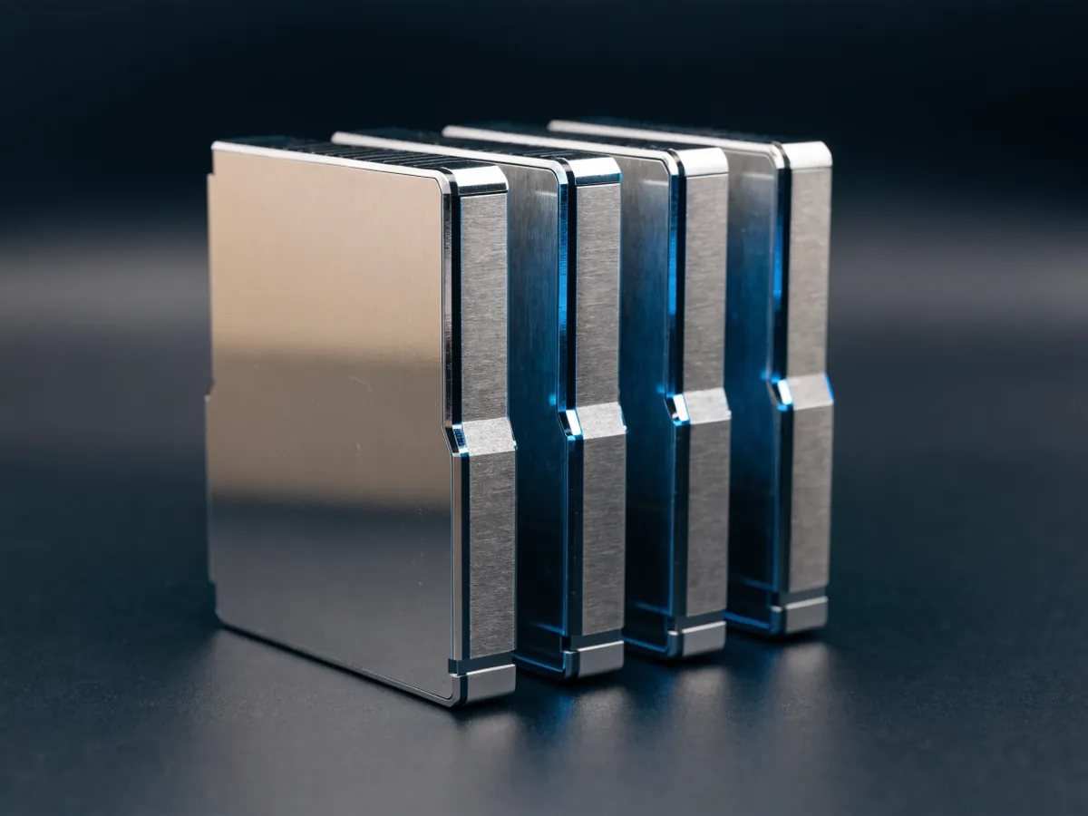 Four thick 2.5 inch enterprise drives standing on edge in a row with their wide segmented contact edges facing forward under blue studio light