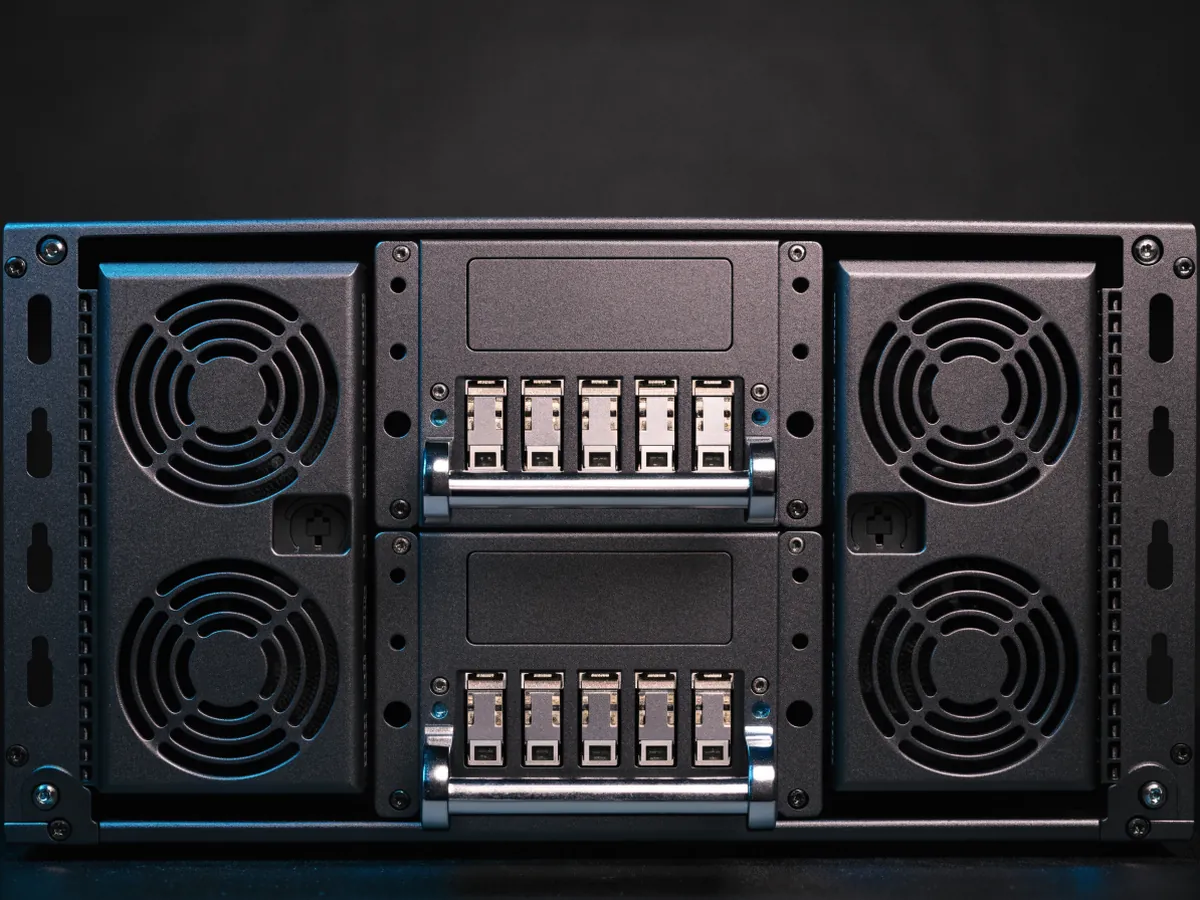 Rear of a two rack unit storage enclosure showing two stacked hot swap input output modules with SAS ports between two power supply modules