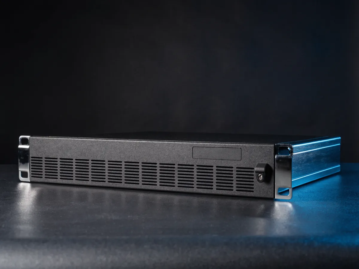 Two rack unit storage enclosure at an angle with its plain front bezel fitted, showing a ventilation grille and an empty badge area
